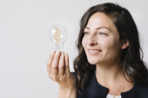 Eine Frau hält eine Energiesparlampe in der Hand.