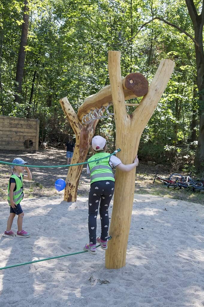 Kind an einem Spielgerät aus Holz auf dem Waldspielplatz Rallenweg