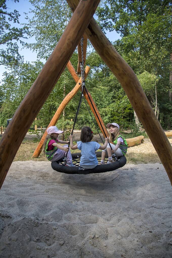 Kinder sitzen in einer Nestschaukel