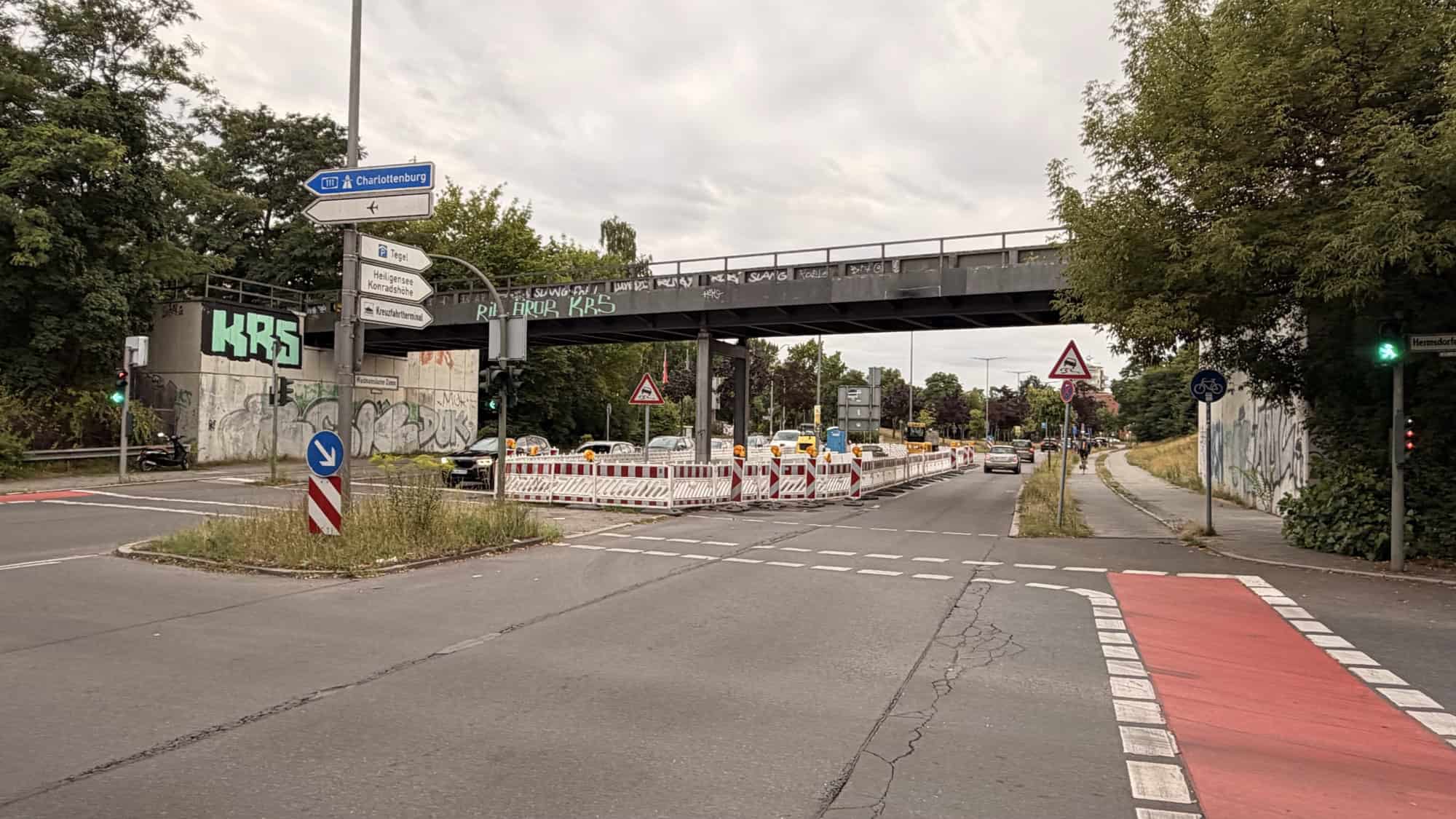 Baustelle mit rot-weißen Absperrbaken auf dem Waidmannsluster Damm unter der Autobahnbrücke der A111