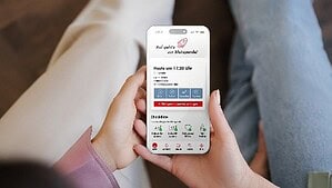Zwei Hände halten ein Smartphone, auf dem Bildschirm ist das Dashboard der DRK-Blutspende-App mit dem nächsten Spendetermin zu sehen.