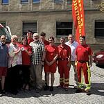 Gruppenfoto vor dem neuen Einsatzfahrzeug der DLRG Reinickendorf: Ehrenamtliche und Gäste, in der Mitte wird die Sondermittelplakette gehalten.