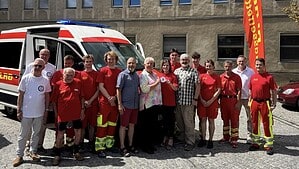 Gruppenfoto vor dem neuen Einsatzfahrzeug der DLRG Reinickendorf: Ehrenamtliche und Gäste, in der Mitte wird die Sondermittelplakette gehalten.