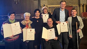 Gruppenfoto der Preisträgerinnen und Preisträger des Reinickendorfer Ehrenpreises 2025 mit Urkunden im BVV-Saal.
