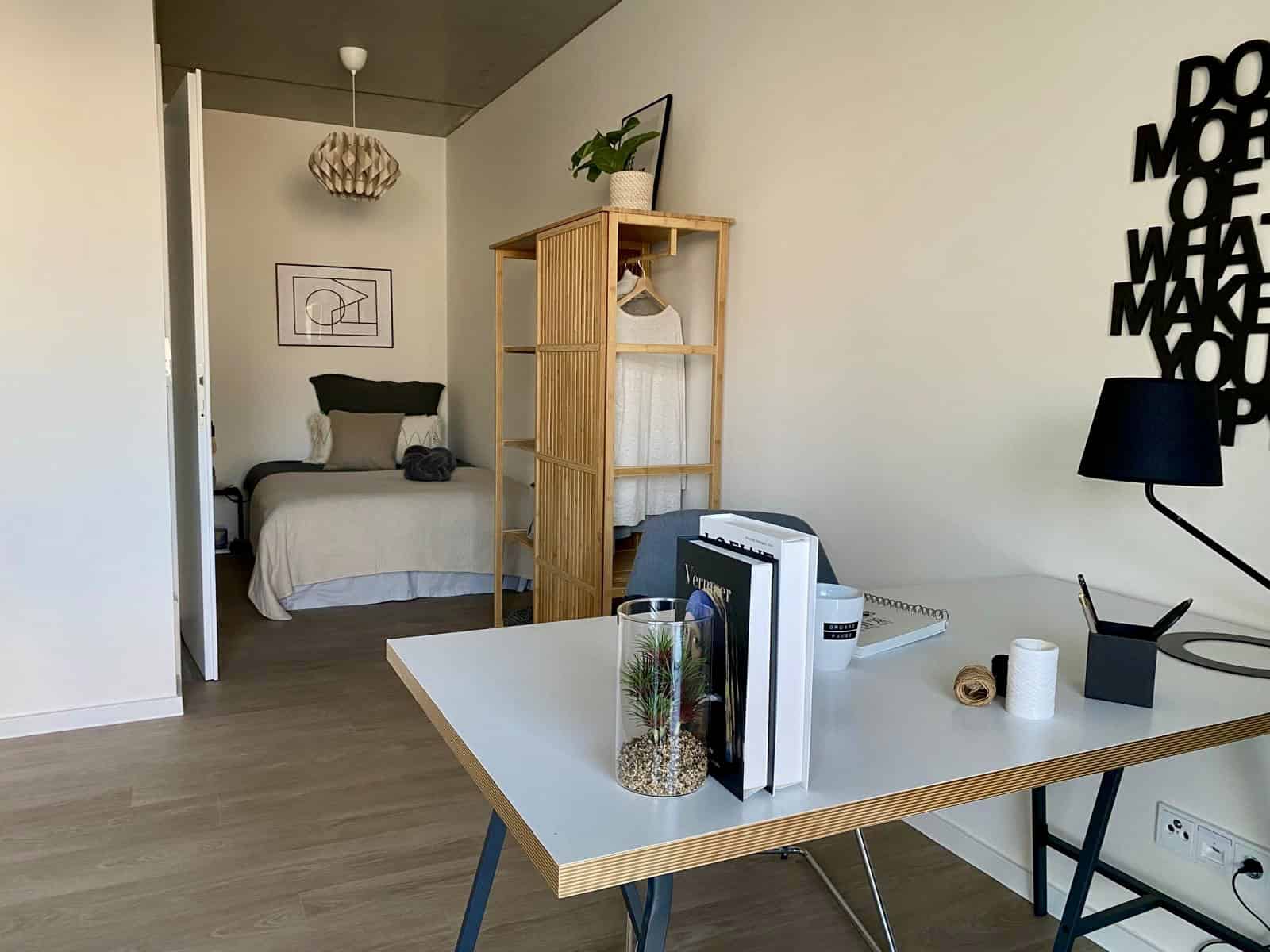 Möblierte Musterwohnung mit Schreibtisch und Schlafbereich