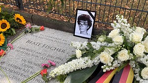 Gedenkplatte für Beate Fischer an der Emmentaler Straße 97 mit Blumen, Trauerkranz und gerahmtem Porträt