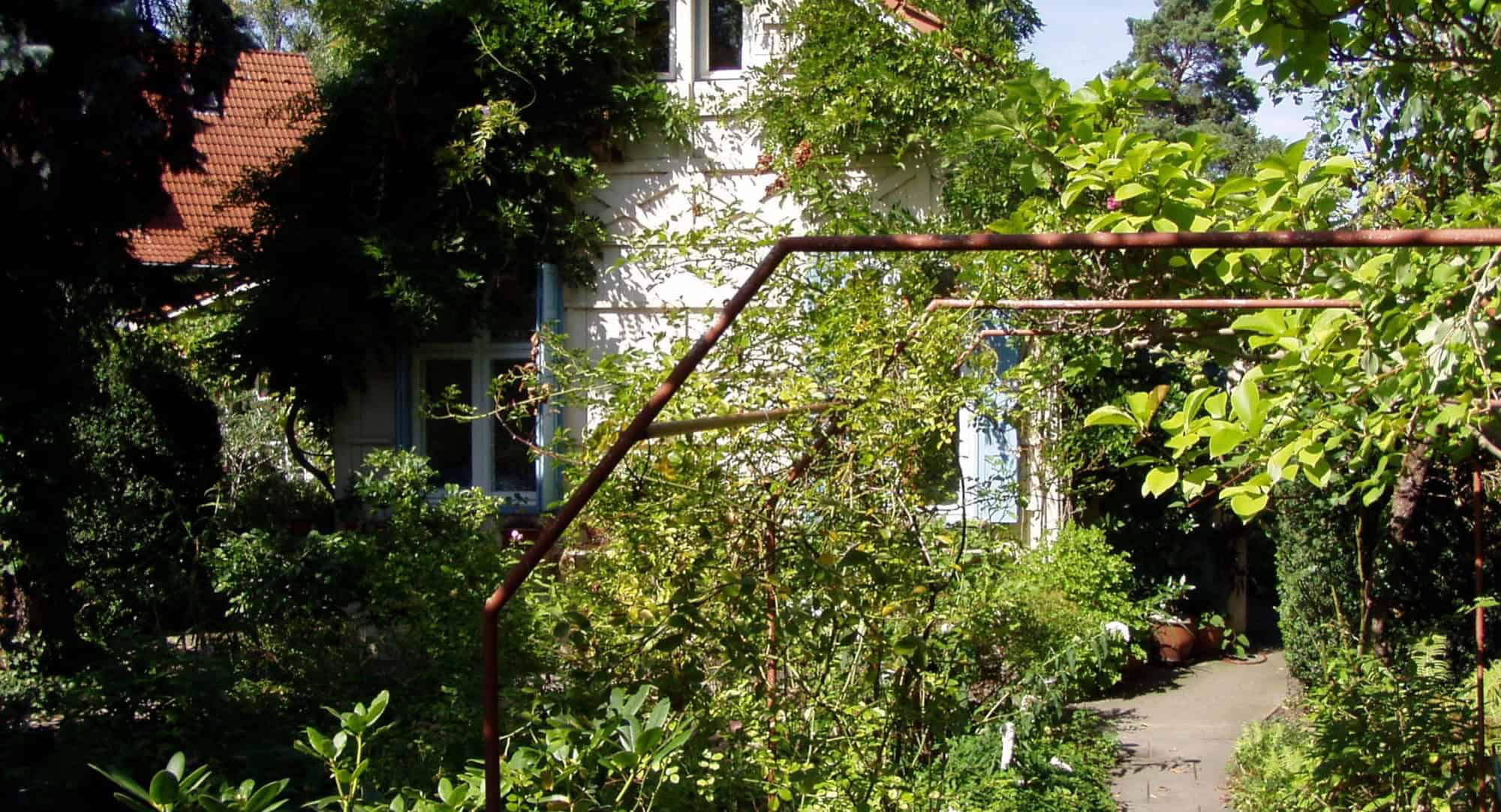 Das Künstlerhaus Hannah Höch mit dicht bewachsenem Garten in Berlin-Heiligensee.