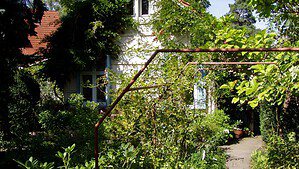 Das Künstlerhaus Hannah Höch mit dicht bewachsenem Garten in Berlin-Heiligensee.