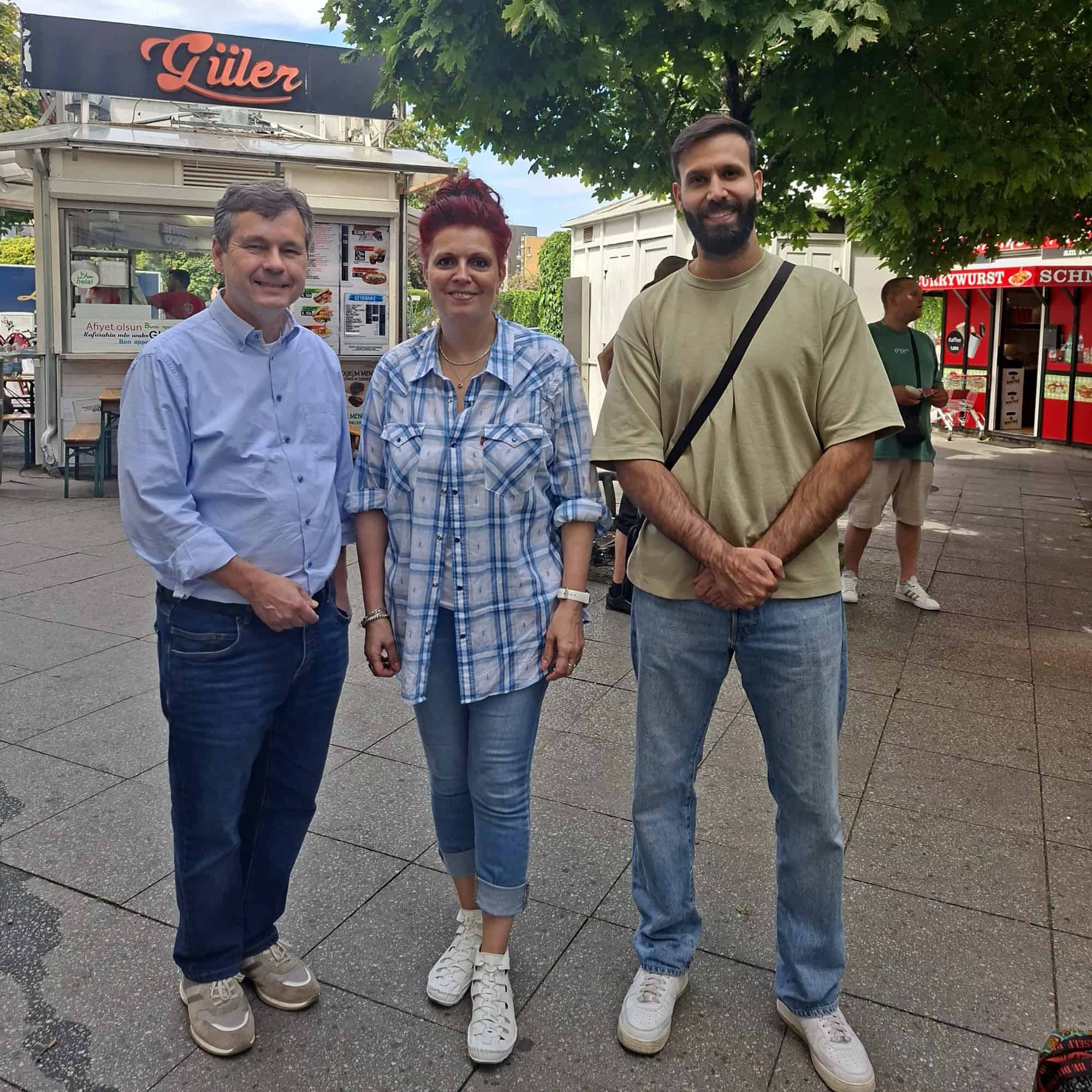 Bezirksstadtrat Uwe Brockhausen mit Berna Ercan und Cagri Coskun von der Horizonte gGmbH am Kurt-Schumacher-Platz
