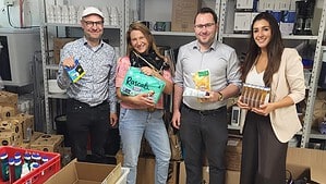 Vier Personen stehen in einem Lagerraum des Diakoniezentrums Heiligensee und halten gespendete Hygieneartikel in den Händen.