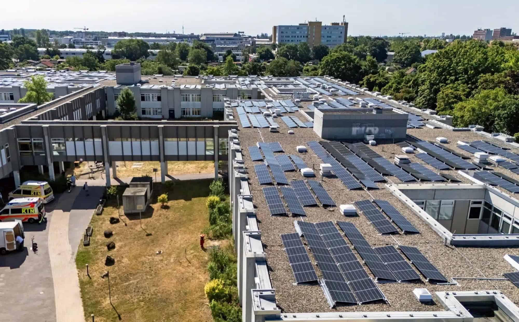 Solarmodule auf den Flachdächern des Humboldt-Klinikums, davor Rettungswagen an der Zufahrt