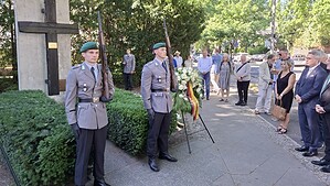 Zwei Soldaten des Wachbataillons stehen als Ehrenposten am Gedenkkreuz mit Mauersegment