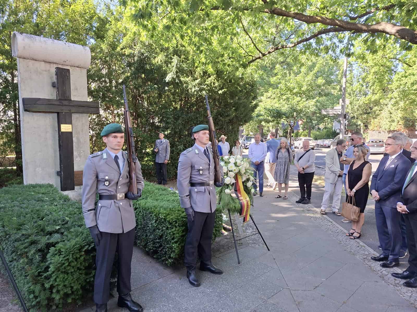 Zwei Soldaten des Wachbataillons stehen als Ehrenposten am Gedenkkreuz mit Mauersegment