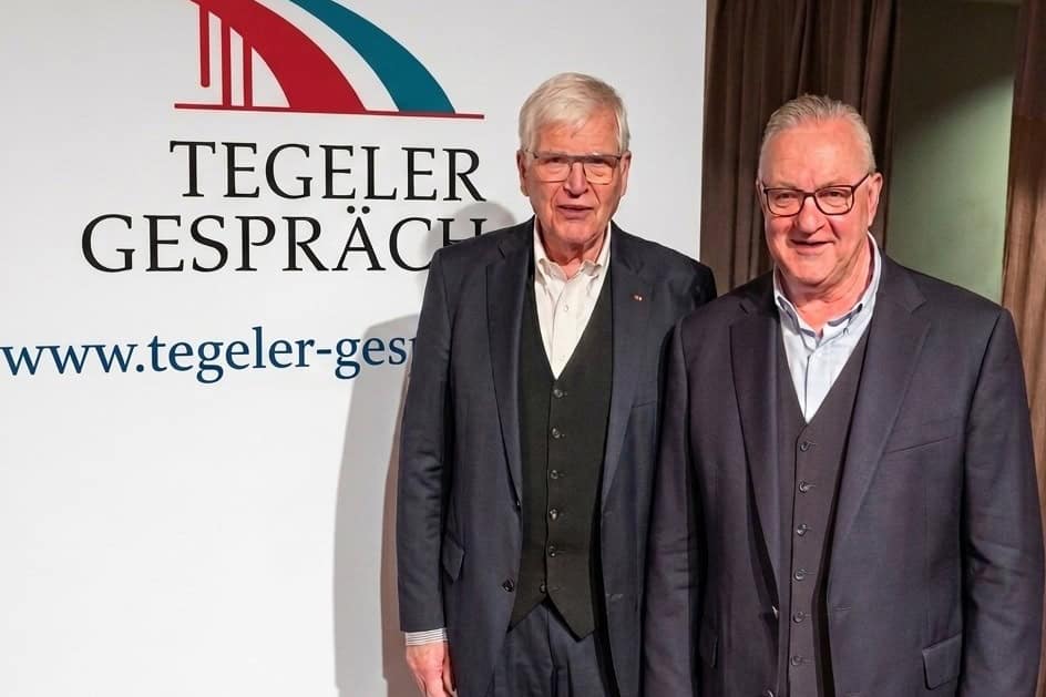 Zwei Herren stehen vor einem Banner mit dem Logo des Vereins Tegeler Gespräch.