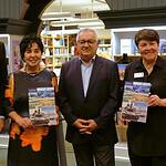 Fünf Personen stehen nebeneinander in der Humboldt-Bibliothek, zwei halten das Buch in den Händen