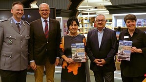 Fünf Personen stehen nebeneinander in der Humboldt-Bibliothek, zwei halten das Buch in den Händen