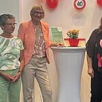 Vier Frauen stehen bei der Jubiläumsfeier des Mobilitätshilfedienstes vor roten Luftballons und einem Schild mit der Zahl 40.