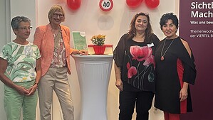 Vier Frauen stehen bei der Jubiläumsfeier des Mobilitätshilfedienstes vor roten Luftballons und einem Schild mit der Zahl 40.