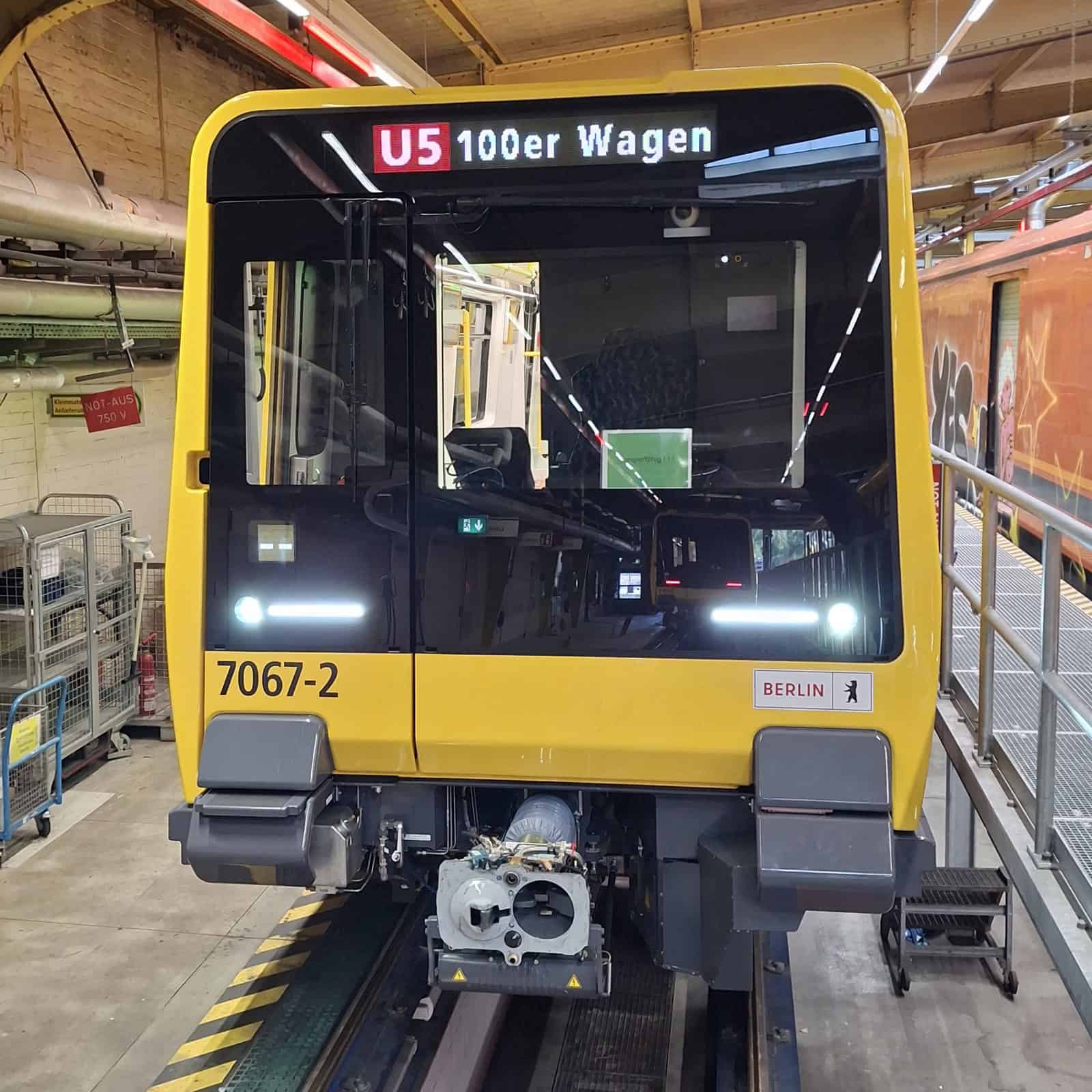 Front eines neuen gelben U-Bahn-Wagens der Baureihe J mit der Anzeige U5 100er Wagen in einer Werkstatthalle