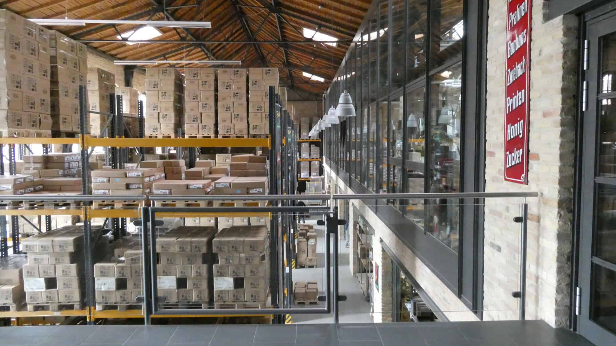 Blick in eine Lagerhalle mit Hochregalen voller Kartons.