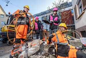 Bauarbeiter verlegen Erdkabel in einem Wohngebiet.