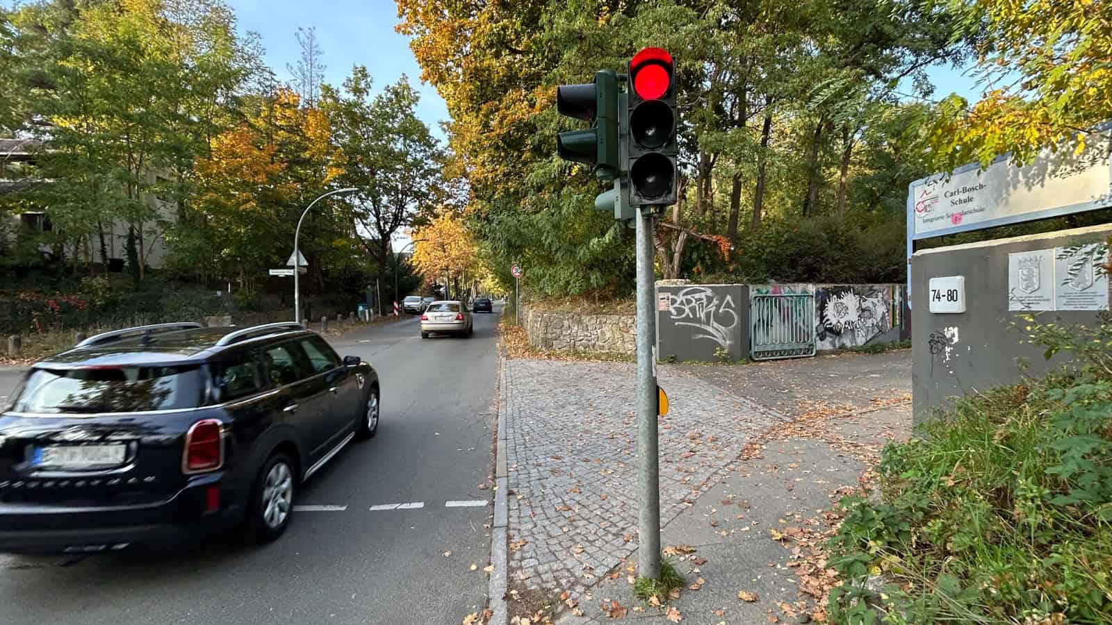 Straße vor der Carl-Bosch-Schule mit Ampel, ein Auto fährt vorbei