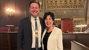 Sebastian Pieper im dunklen Anzug mit goldener Amtskette und Emine Demirbüken-Wegner im weißen Blazer stehen lächelnd nebeneinander in einem holzgetäfelten Sitzungssaal.