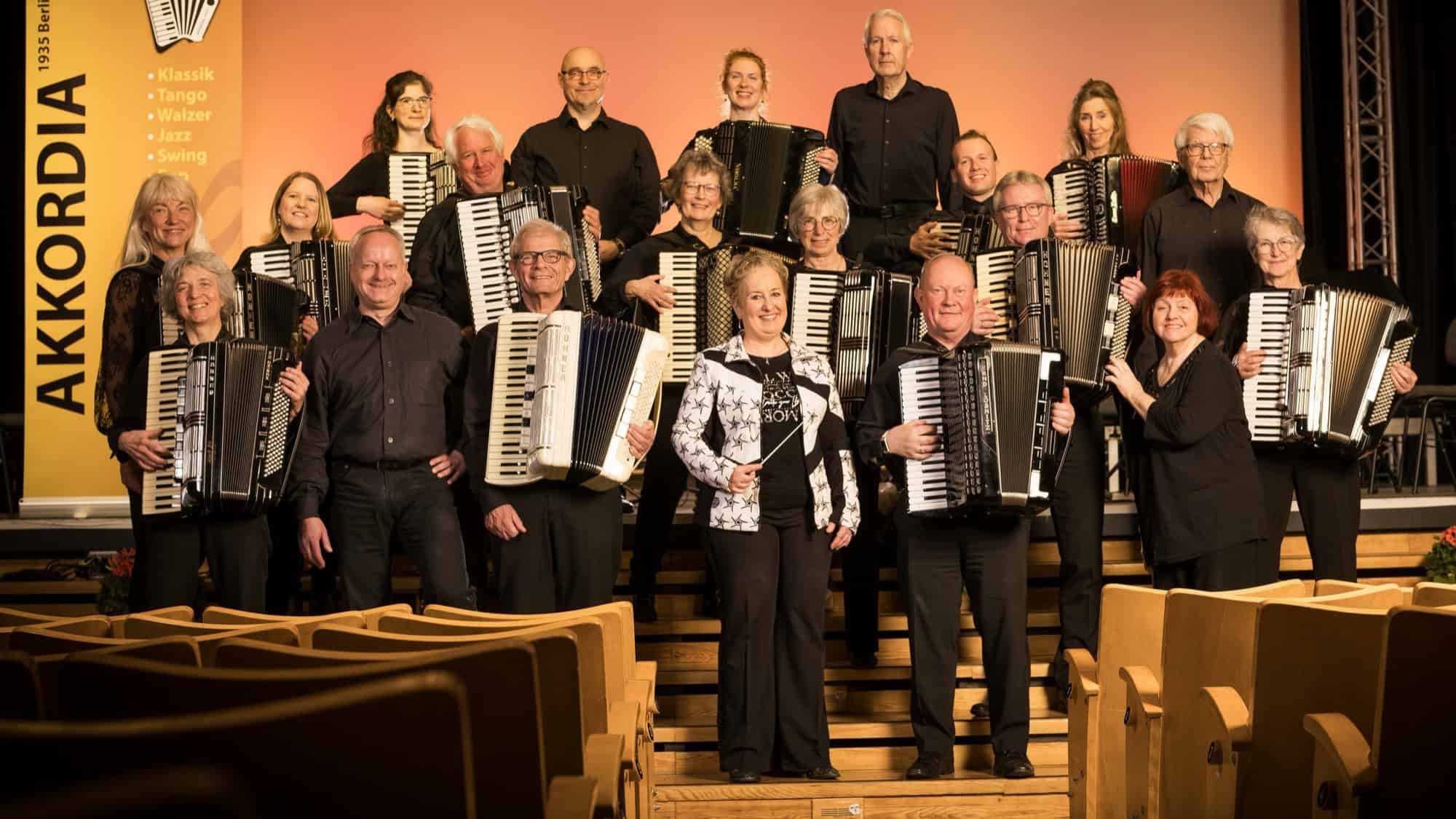 Gruppenbild des Akkordeonorchesters Akkordia 1935 Berlin mit rund 25 Musikerinnen und Musikern und ihren Instrumenten auf einer Bühne