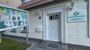 Eingang des Barbara-Schulz-Hauses in Alt-Hermsdorf mit Schaukasten und Schild des Vereins Kinderhilfe